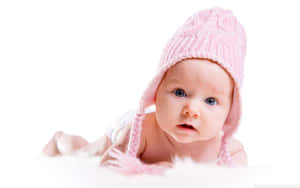 Baby wearing pink knit hat on fluffy white surface — Baby Picture