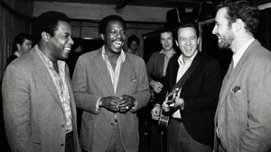 Et uformelt øyeblikk bak scenen der Elmore James og bandet hans deler en latter.