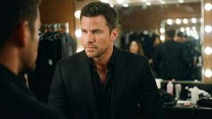 Channing Tatum backstage in a suit, thoughtful expression in mirror.