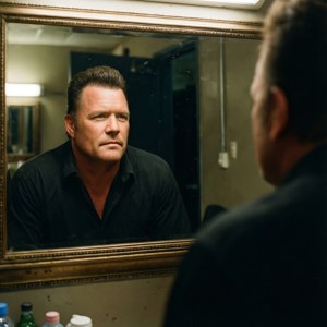 Garth Brooks backstage in de spiegel kijkend, reflecterende stemming.