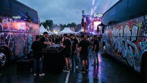 Escena sincera detrás del escenario en el Ultra Music Festival con DJs y fans en iluminación ambiental