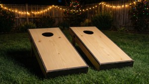 Ein festlicher Hinterhof-Cornhole-Aufbau mit Lichterketten bei Nacht.