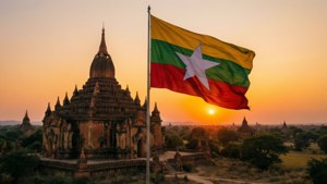 Myanmars flagga som vajar över Bagan-tempel under solnedgången.