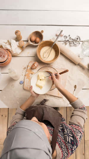 Person preparing dough with butter on a wooden table. — Baking iPhone Picture