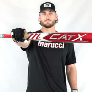 Man holding a baseball bat in a studio setting.