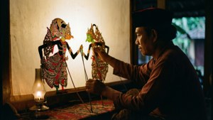 Burattinaio Dalang manipola burattini Wayang dietro lo schermo