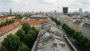 An aerial rooftop view of Berlin's cityscape with a mix of architecture and greenery.