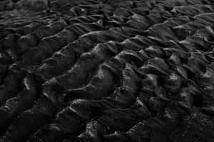 Nærbilde av mørkt kruset sand med finkornet tekstur. — Black Aesthetic Phone Bakgrunner