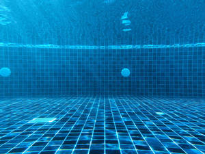 Underwater pool with blue tiled floor and rippling surface light. — Blue Checkered Picture