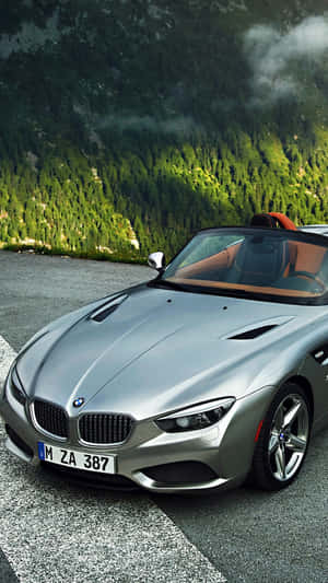 Silver BMW Z8 convertible parked on a mountain road with forest and misty peaks. — Bmw Android Picture