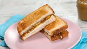 Golden grilled cheese sandwich with caramel sauce on pink plate and blue napkin. — Bread Background