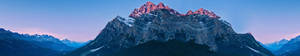 Snow-capped mountains glowing pink at twilight with deep blue shadows. — Three Screen Picture