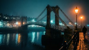 Pemandangan malam jembatan ayun Whitby dengan pantulan bercahaya di Sungai Esk