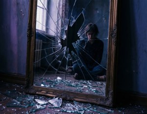 Ein zersprungener Spiegel, der eine einsame Figur reflektiert und ein verletzliches Selbstbild symbolisiert.