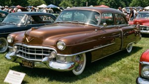 Une Cadillac Brougham marron lors d'un salon de voitures classiques, restauration impeccable.