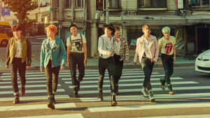 Sete jovens elegantes atravessando uma rua da cidade ao pôr do sol. — Bts Mac Papéis de Parede