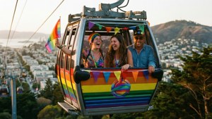 Venner på en regnbue-dekoreret kabelvogn under SF Pride