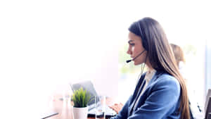 Kvinna i blå kavaj använder bärbar dator med headset i ljust kontor — Samtal bakgrund Bakgrundsbilder