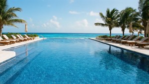 Uendelig basseng med utsikt over Det karibiske hav ved et feriested i Cancun.