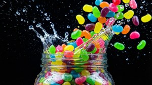 Una explosión colorida de Jelly Beans y salpicaduras de agua sobre negro, fotografía de alta velocidad