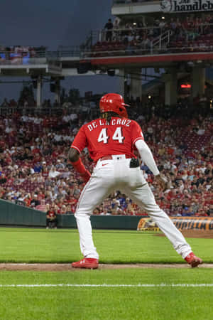 Baseball player De La Cruz at bat in red uniform during evening game. — Coupe Picture