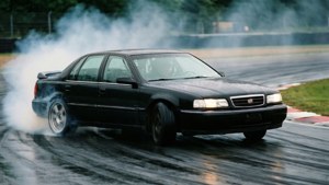 Sebuah Cadillac Catera hitam yang meluncur, performa dan handling dalam aksi.