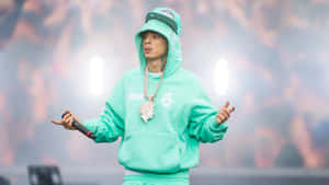 Rappeur se produisant sur scène en sweat à capuche vert menthe et casquette avec des lumières vives et de la fumée.