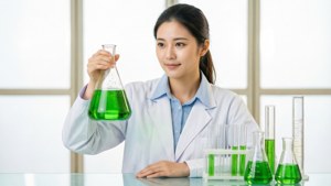 A woman scientist experimenting with colorful chemicals in a modern lab. — Science Wallpaper