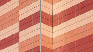 Nahaufnahme einer modernen Gebäudefassade mit Chevron-Muster in warmen Tönen — Chevron Wallpaper