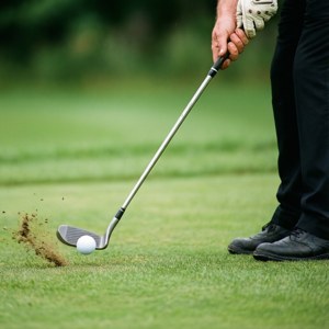 Primo piano dell'azione di chipping di Jeff Maggert, con focus su mani e mazza.