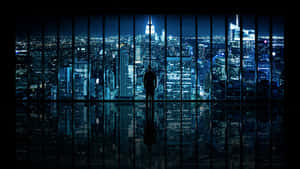 Uma pessoa está sozinha em uma janela com vista para uma cidade brilhante à noite, com arranha-céus e reflexos. — Scenecore Papéis de Parede