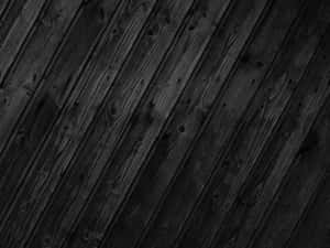 Dark wooden planks with visible grain and knots in monochrome.
