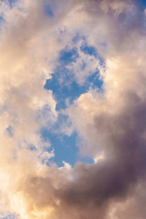 Dramatic sunset clouds in gold and purple against a clear blue sky. — Clouds Background