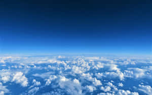 Vast expanse of fluffy white clouds under a clear blue sky.