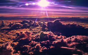 Aerial view of clouds glowing in purple and orange at sunset with radiant sun overhead. — Clouds 4K Wallpaper