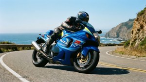 Een Suzuki Hayabusa die door een schilderachtige kustbocht snijdt.