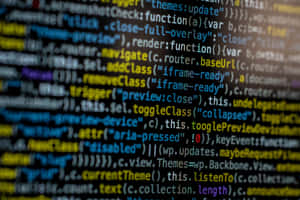 Blurred lines of colorful computer code on a dark screen. — Code Wallpaper