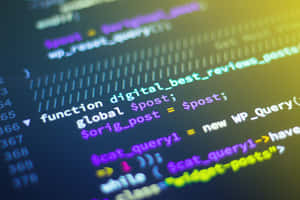 Close-up of colorful programming code on a dark screen with a yellow glow. — Code Wallpaper