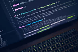 Laptop keyboard with glowing keys and screen showing colorful code in dark room. — Code Wallpaper