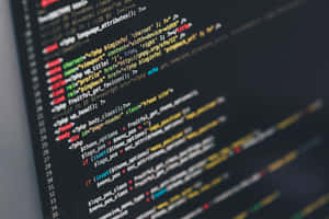Close-up of colorful programming code on a dark computer screen. — Code Wallpaper