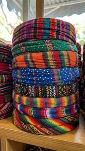 A vibrant stack of patterned yamakas on a shelf.