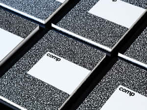 Stacked composition notebooks with black speckled covers and white labels.