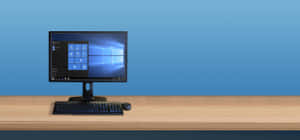 Black desktop computer on wooden desk with blue background — Computer Keyboard Wallpaper