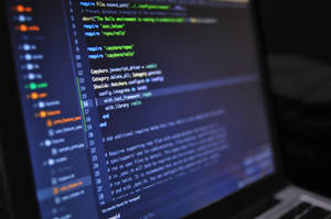 Laptops skjerm som viser Ruby on Rails-programmeringskode med uskarpt tastatur.