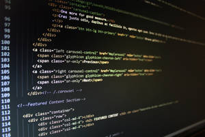 Close-up de código de computador brilhante em uma tela escura. — Tela do computador Foto Papéis de Parede
