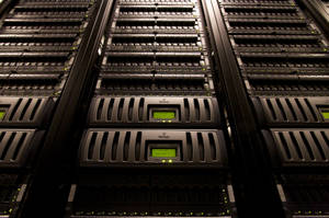 Rows of black server racks with green indicator lights in a data center. — Data Wallpaper