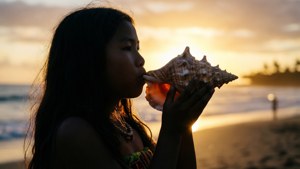 Une fille tongienne soufflant dans une conque au coucher du soleil, silhouette.