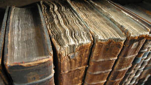 Reihe alter ledergebundener Bücher mit abgenutzten Buchrücken und ausgefransten Seiten. — Coole Vintage bilder Hintergrund Wallpaper