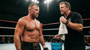 Wrestler and coach in ring after match with towel and bucket
