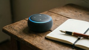 Un Echo Dot in un angolo dello scrittore con taccuino e penna.